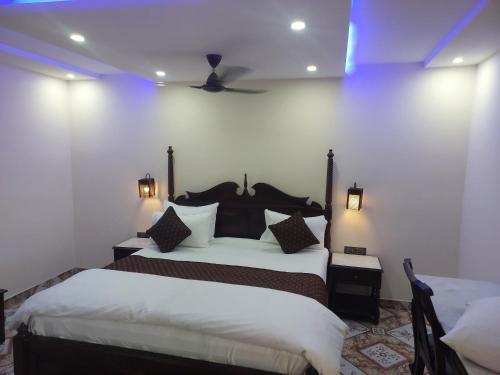 a bedroom with two beds and a ceiling fan at HOTEL TOURIST REST HOUSE Agra in Agra