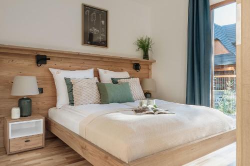 a bedroom with a large bed and a window at Apres Ski Bachleda - LoftAffair Collection in Zakopane