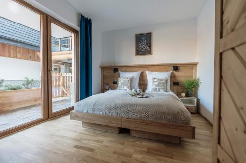 a bedroom with a large bed and a large window at Apres Ski Bachleda - LoftAffair Collection in Zakopane