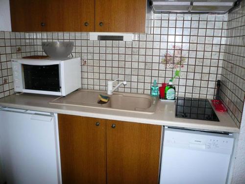 une cuisine avec un évier et un micro-ondes dans l'établissement Résidence L'ecrin Des Glaciers Isard - Ecrin des Glaciers I2 MAE-5315, à Combloux