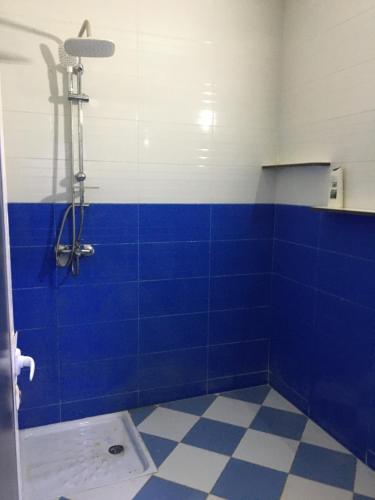 a blue tiled bathroom with a shower and blue tiles at larc in Deroua