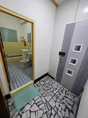 a bathroom with a door with a toilet and a shower at 高鐵中彰309民宿 in Changhua City