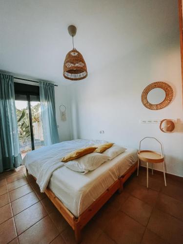 a bedroom with a bed and a chair and a mirror at Villa Vanilla charming family house in Lajares