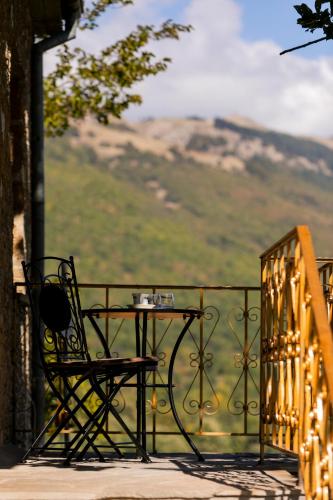 a table and chair on a balcony with a view at Villa Natsi in Aspróyia