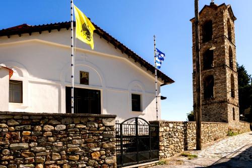 a building with a flag and a tower at Villa Natsi in Aspróyia