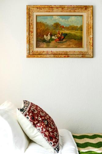 a painting on the wall above a couch with a pillow at Villa Natsi in Aspróyia
