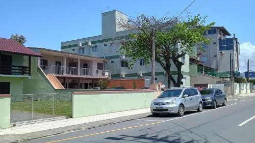 two cars parked on the side of a street at Aptos Enseada Prox Praia in São Francisco do Sul