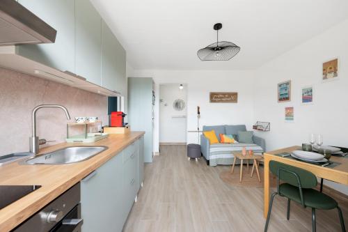 Il dispose d'une cuisine avec un évier et d'un salon avec un canapé. dans l'établissement Vista Nissa - À Quelques Pas du Port, à Nice