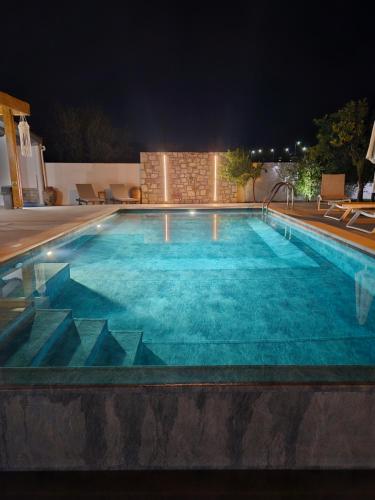 a large swimming pool at night at Villa Costazia in Kalithies