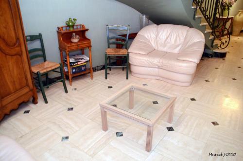 a living room with a glass coffee table and a couch at Le Pigeonnier in Saint-Martin-le-Beau