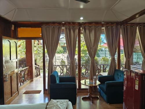 a living room with two blue chairs and a table at Yerrata Resorts in Havelock Island