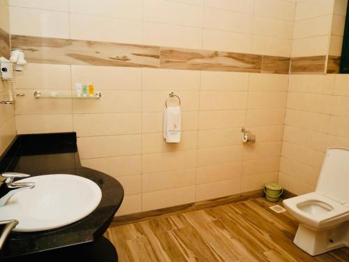 a bathroom with a sink and a toilet at Nile Village Hotel & Spa in Jinja