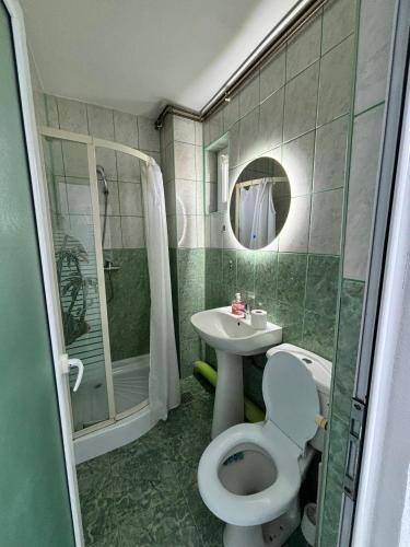 a bathroom with a toilet and a sink and a shower at Grey Residence in Drobeta-Turnu Severin