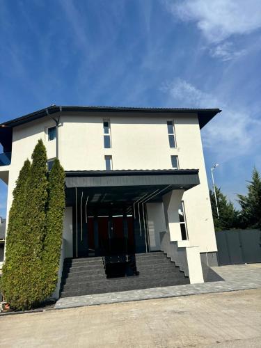 a large white building with stairs in front of it at Grey Residence in Drobeta-Turnu Severin