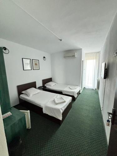 a hotel room with two beds and a window at Grey Residence in Drobeta-Turnu Severin