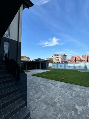 a house with a patio and a grass yard at Grey Residence in Drobeta-Turnu Severin