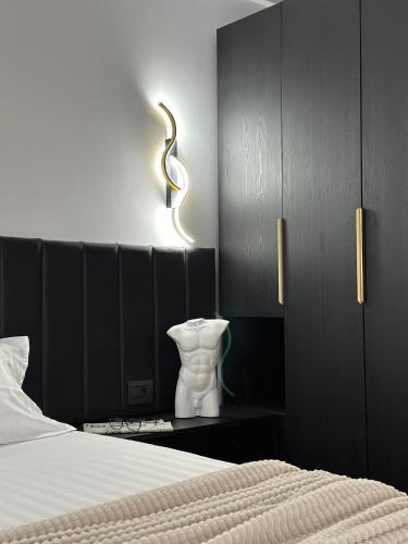 a bedroom with a bed and a vase on a table at Grey Residence in Drobeta-Turnu Severin