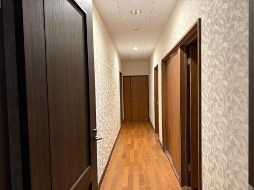 an empty hallway with a door and a hallway sidx sidx at Hotel Junior Mint Hakuba in Hakuba