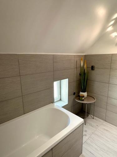 a large white tub in a bathroom with a table at Apartament Biały Kamień in Wałbrzych