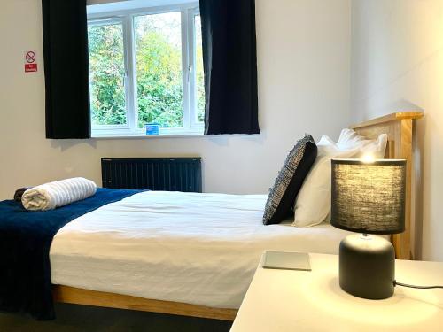 a bedroom with a bed and a desk with a lamp at Large 5 bed detached house near Stansted Airport with Parking for 2 vehicles! Stansted Stays in Stansted Mountfitchet