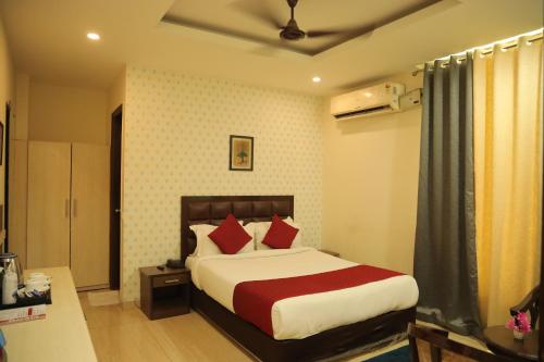 a bedroom with a large bed with red pillows at Hotel Nirvana Suites in New Delhi