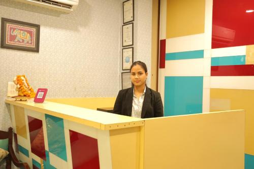 a woman sitting at a desk in an office at Hotel Nirvana Suites in New Delhi