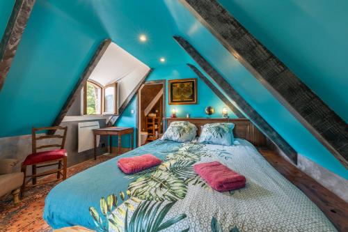 une chambre bleue avec un lit avec deux oreillers dans l'établissement Superbe chaumière en bord de mer, à Fouesnant