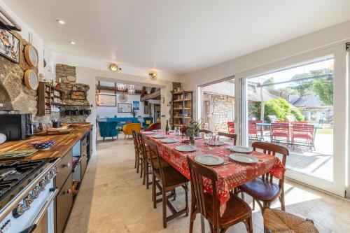 une salle à manger avec une longue table avec des chaises dans l'établissement Superbe chaumière en bord de mer, à Fouesnant