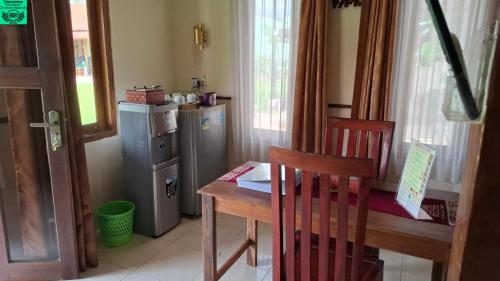a small kitchen with a table and a small refrigerator at Alamanda Family Villas, Pool & Local Tours in Yogyakarta
