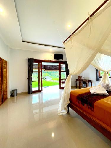 a bedroom with a bed with a mosquito net at Tirta Unda Sidemen in Sidemen