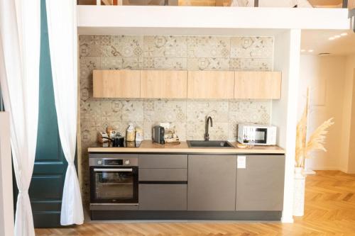 a kitchen with a sink and a microwave at Centro Storico Rooms & Suites in Manfredonia