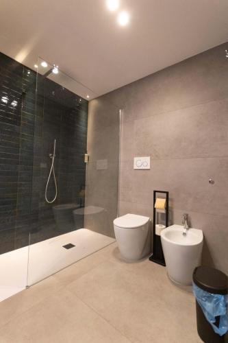 a bathroom with a shower and a toilet and a sink at Centro Storico Rooms & Suites in Manfredonia