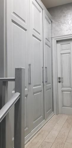 a white kitchen with a door and a wooden floor at Грибовка Апартаменты 134 - 137 Black Sea Bugaz in Gribovka