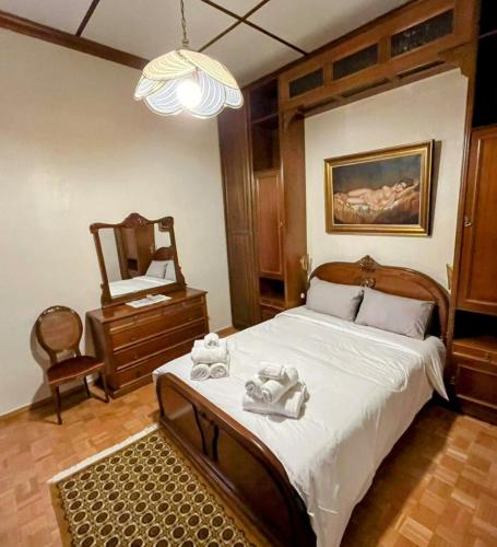 a bedroom with a bed with a mirror and a dresser at Κομψό & πολυτελές νεοκλασικό στο κέντρο της πόλης in Kastoria