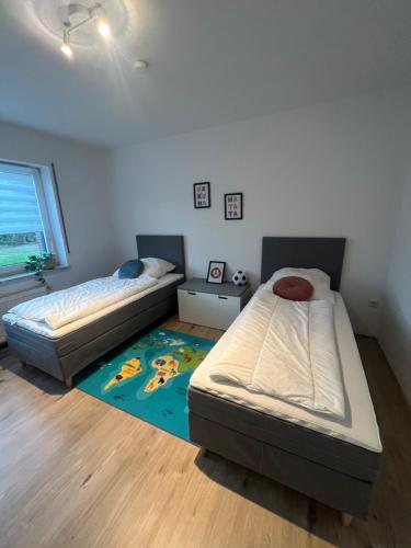 a bedroom with two beds and a rug at Ferienhaus Küstenbär Burhave in Burhave