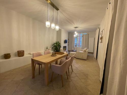 une salle à manger avec une table et des chaises et un salon dans l'établissement Duplex en rez-de-chaussée avec cour intérieure privée, proche de la mer, WIFI, à Mers-les-Bains