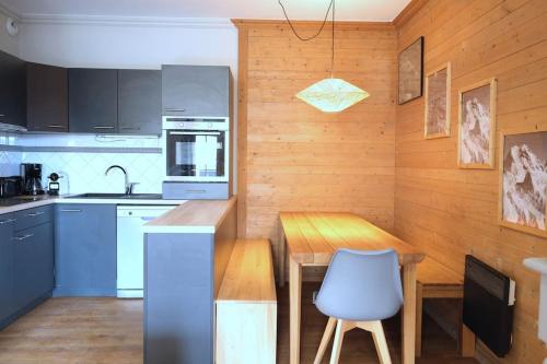 a kitchen with a table and a blue chair at Appartement 8 personnes dans chalet privé au pied des pistes in Val Thorens