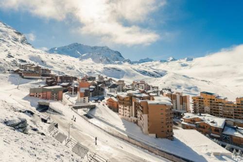 a city covered in snow with mountains in the background at Appartement 8 personnes dans chalet privé au pied des pistes in Val Thorens