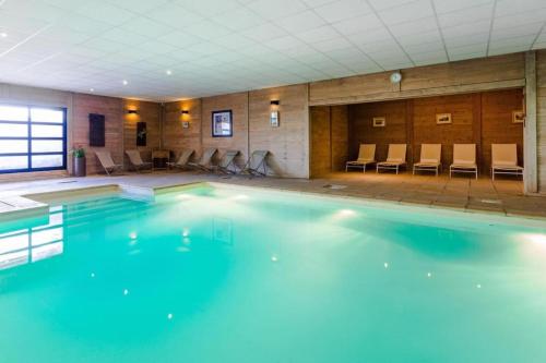 a large swimming pool in a room with chairs at Appartement 8 personnes dans chalet privé au pied des pistes in Val Thorens