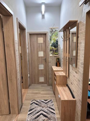 a bathroom with a wooden door and a mirror at Alberta Apartments in Braşov