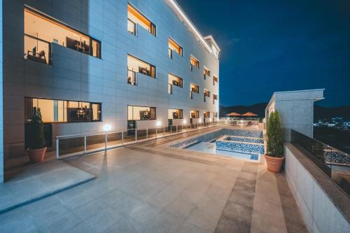 a building with a swimming pool in front of it at Wonju city hotel in Wonju