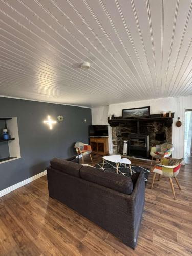 un salon avec un canapé et une cheminée dans l'établissement Gîte de Pennenez, à Plomodiern