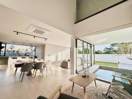 a living room with a table and chairs and a pool at Maerim Peaceful in Ban Pa Muang