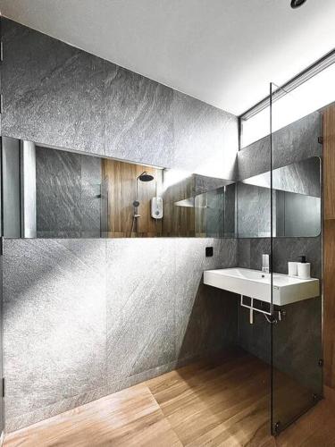 a bathroom with a sink and a glass shower at Maerim Peaceful in Ban Pa Muang