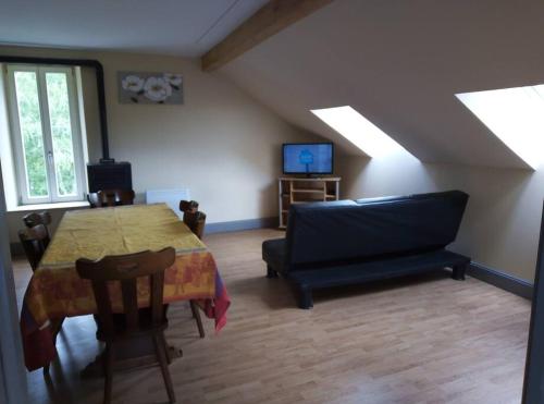 a living room with a table and a couch at Nouveau loft à moins de 100m du lac classé 2 étoiles in Gérardmer