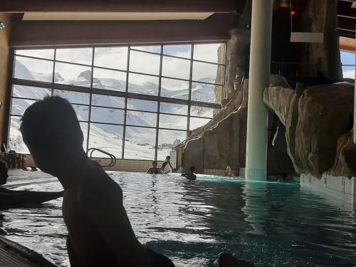 une personne dans une piscine avec vue sur la montagne dans l'établissement Appartement dans ferme 7 personnes, à Bourg-Saint-Maurice