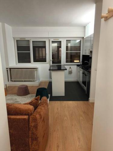 un salon avec un canapé et une cuisine dans l'établissement Studio pour 1 à 4 pers localisé dans un quartier chic, à Paris