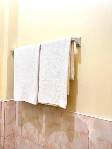 a towel rack with white towels hanging on a wall at C View Resort in Sipalay
