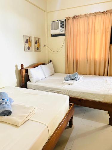 a room with two beds and a tv at C View Resort in Sipalay