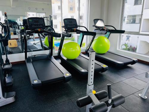 um ginásio com várias passadeiras e bolas de exercício em Giana’s stays with pool em Mombaça